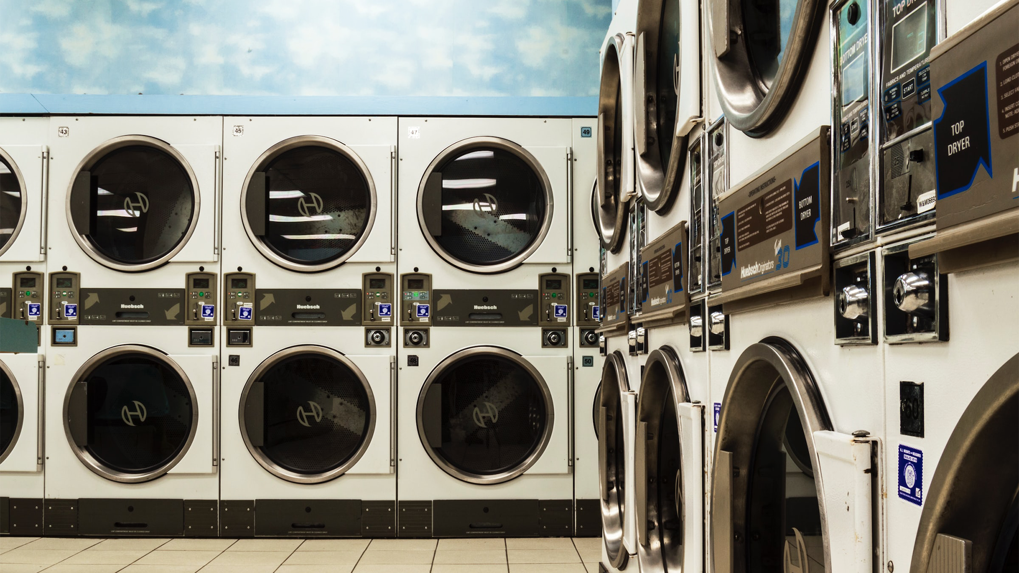 Washing machines stacked in two rows in a laundromat