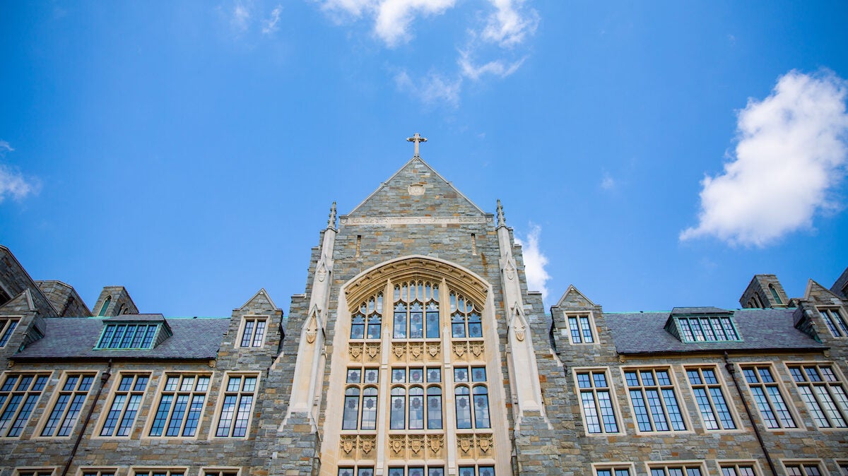 Old stone building with a cross at the top of the pointed roof