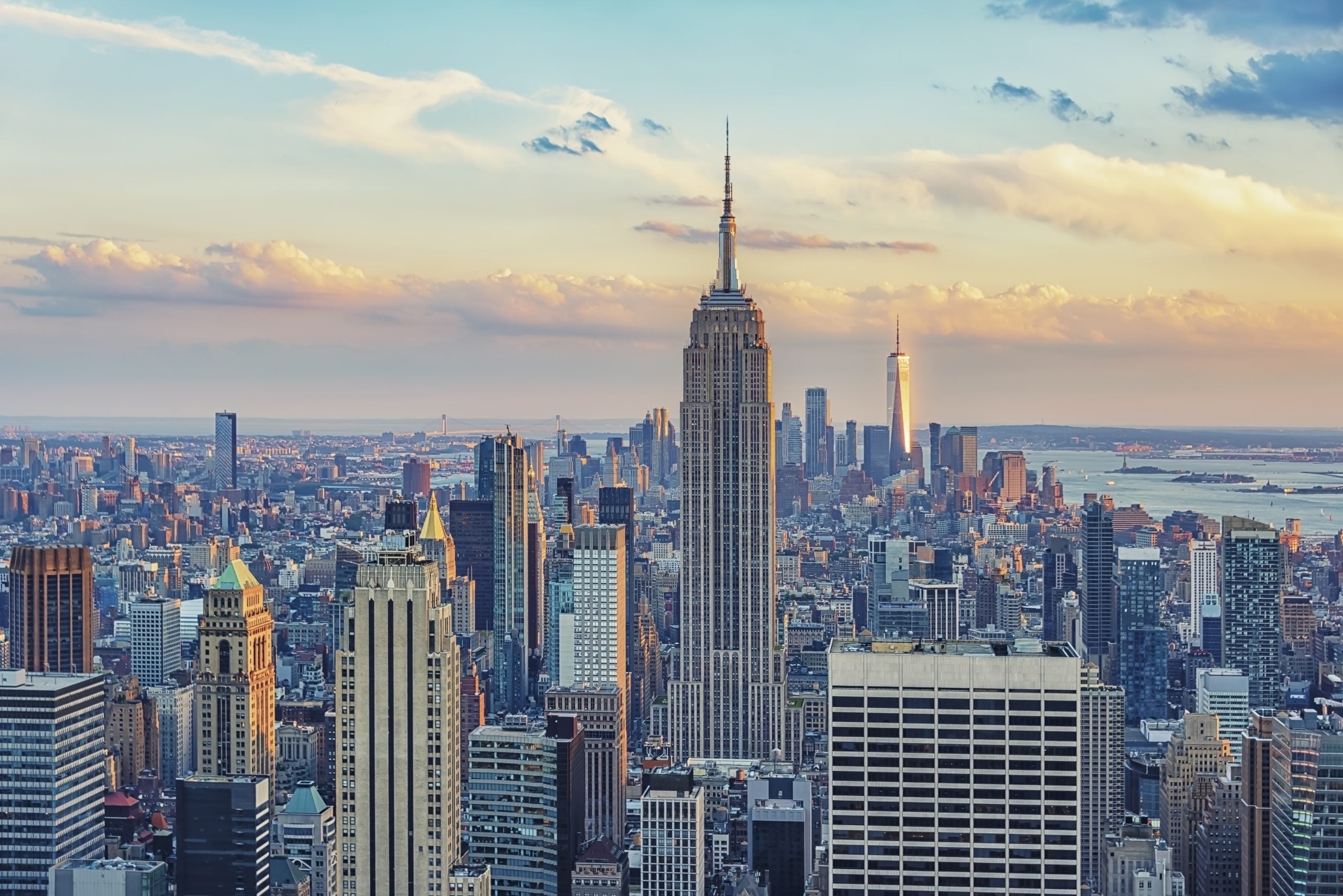 An image of the New York City skyline against a pink and blue sky.