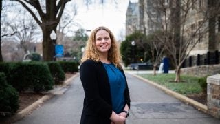 Jessica Ballou smiles with hands folded on a winter day outside of Copley Hall.