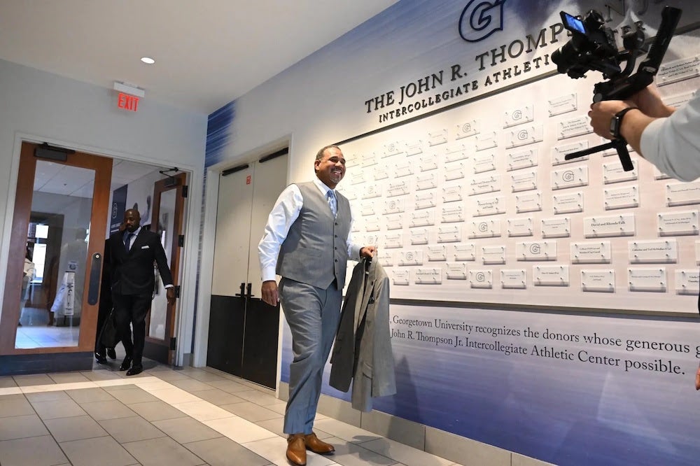 Ed Cooley walks with jacket in hand.