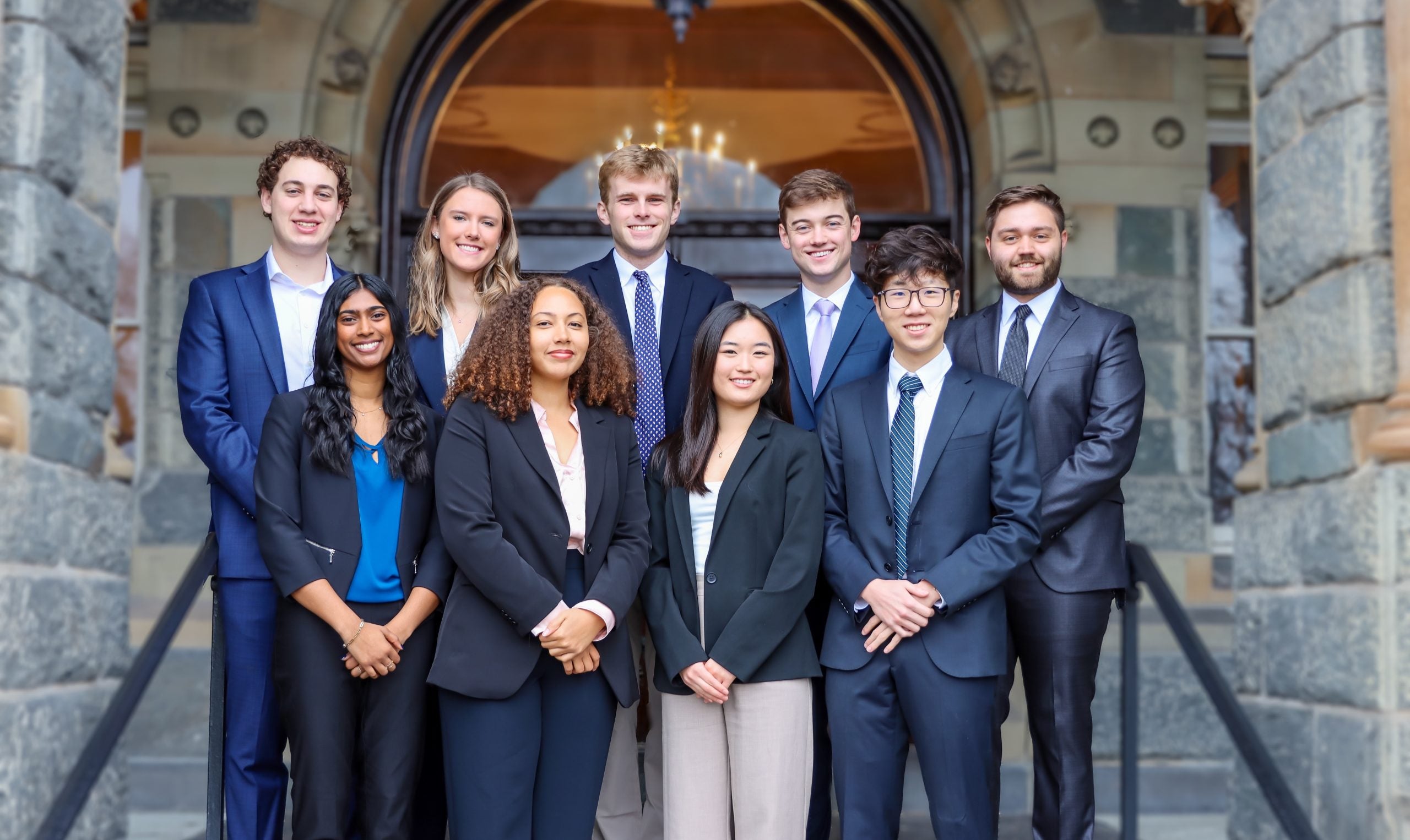 The credit union's 9-person Board of Directors poses for a photo on the steps of Healy Hall