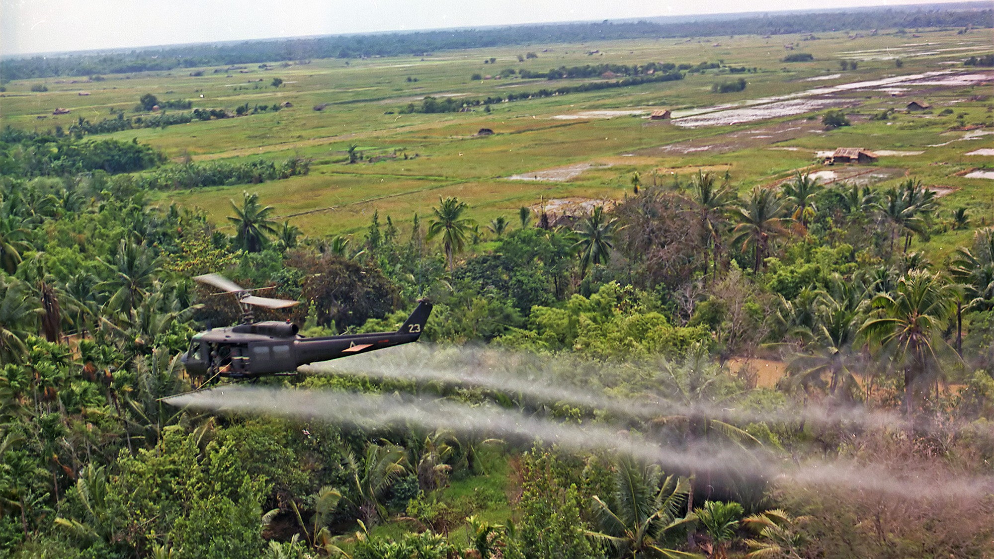 Helicopter flies over field