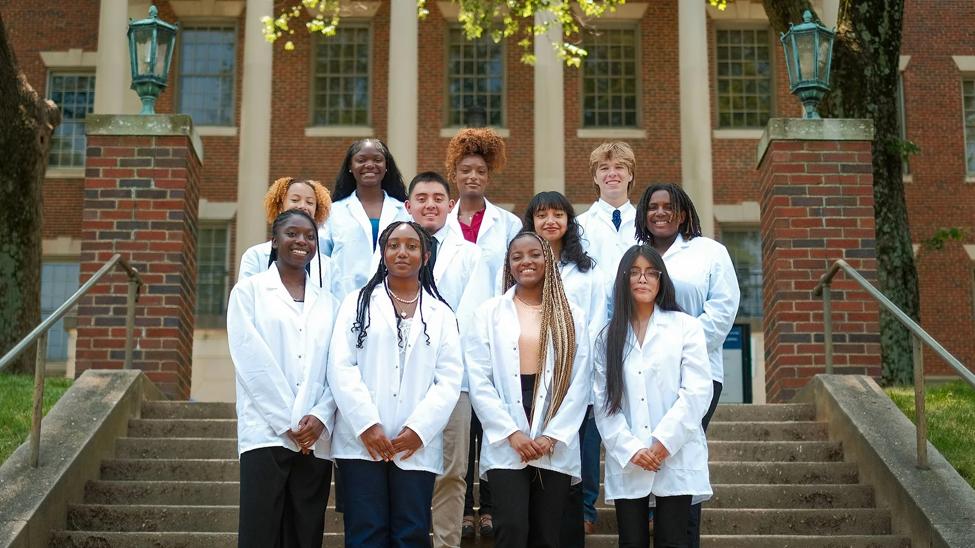 A group of 10 high school students in white coats