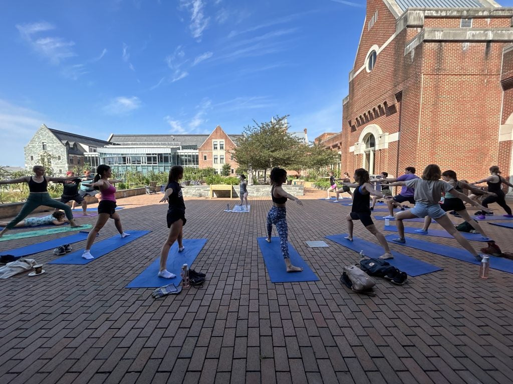Individuals practicing yoga outside, on Georgetown campus.