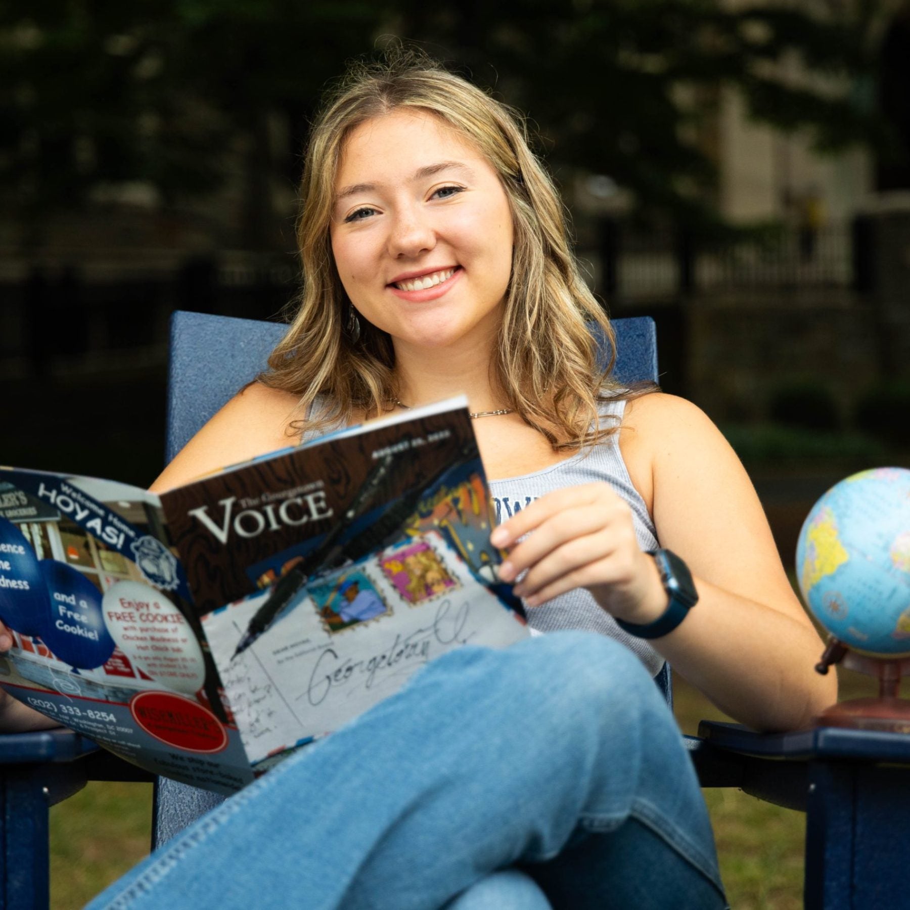 Ninabella Arlis sitting on a chair with a magazine