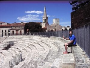 Man in blue shirt sitting in amphitheater 