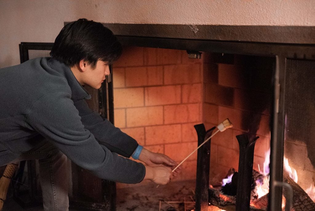 Bennie roasts marshmallows over a fire