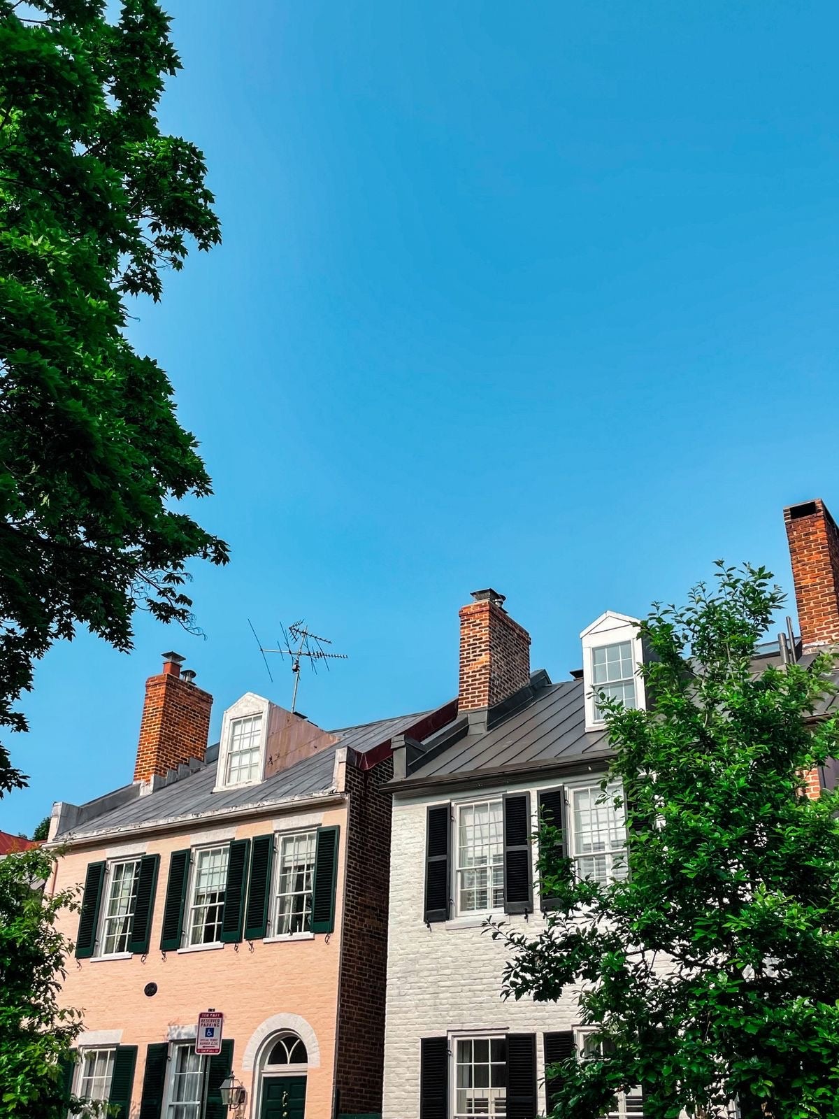 Two row homes backed against a blue sky