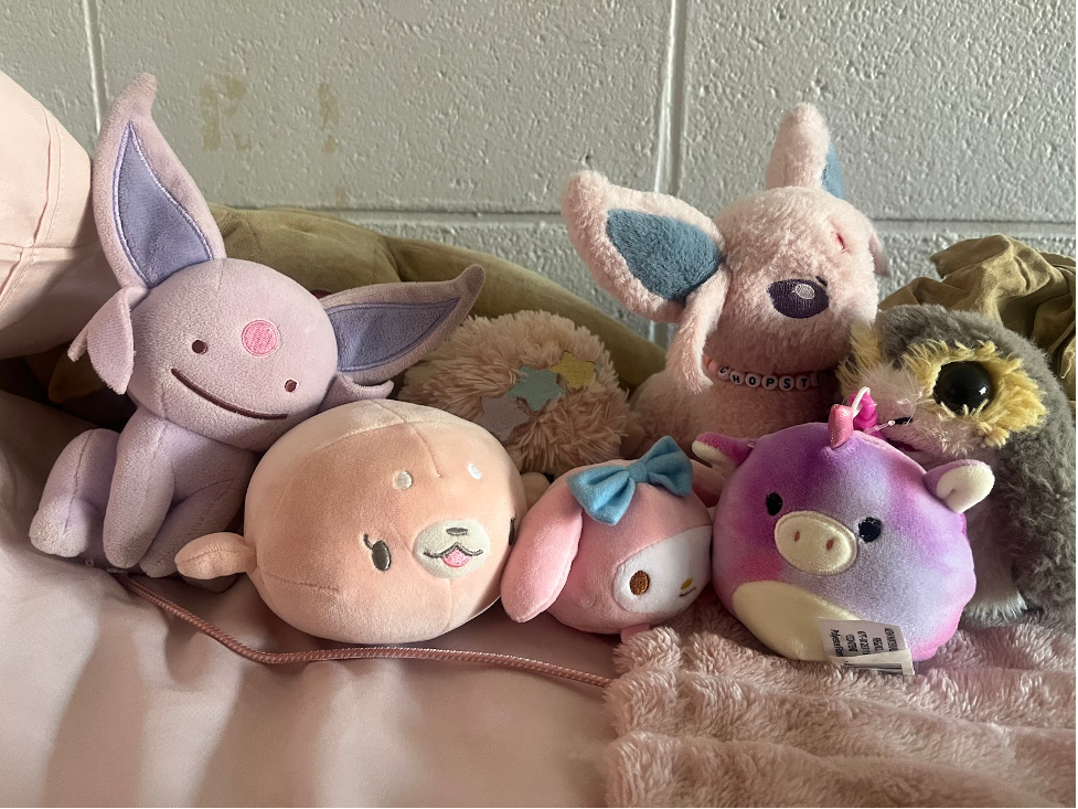 Six stuffed animals on top of a dorm bed