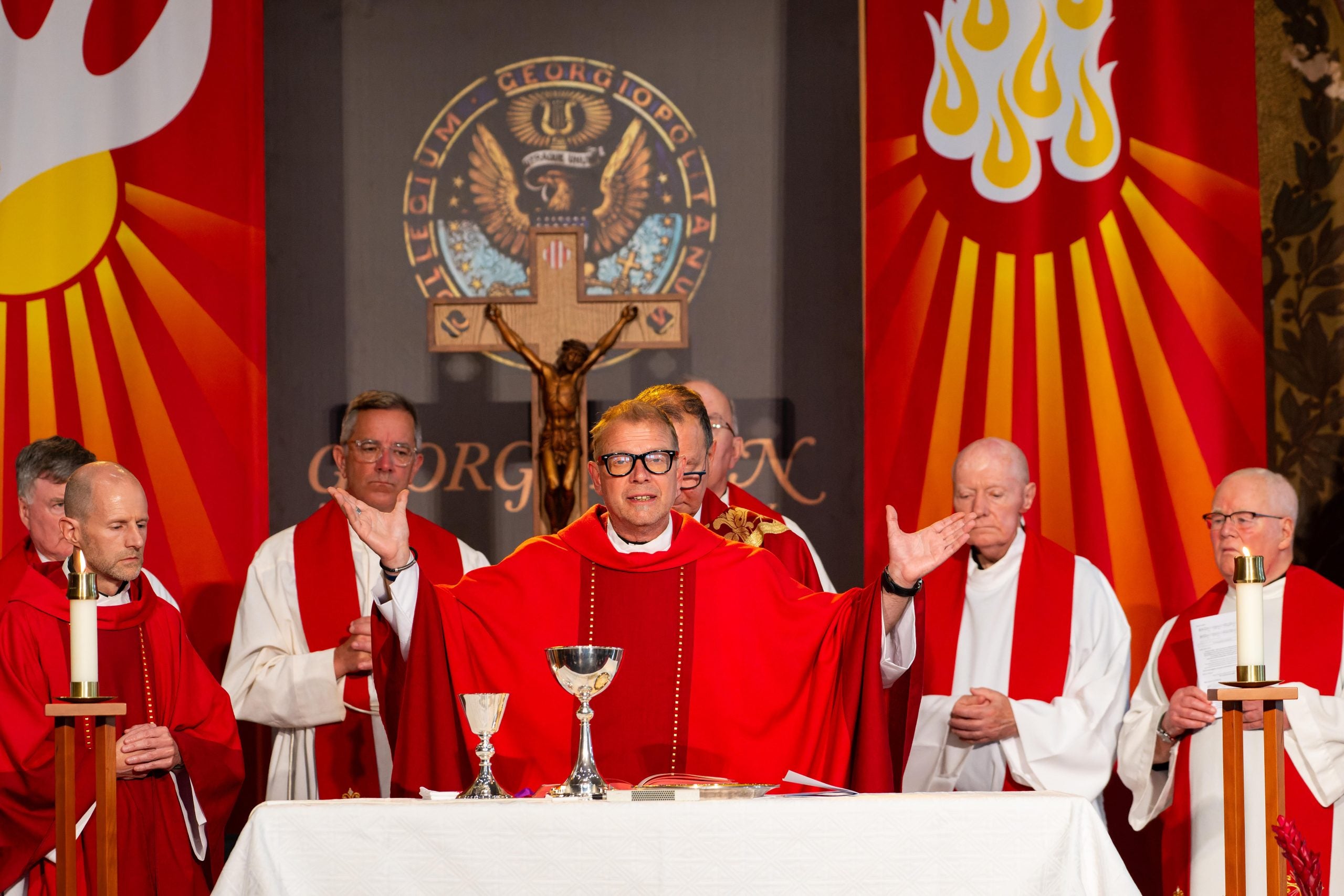 Catholic priest in red garments celebrates Mass