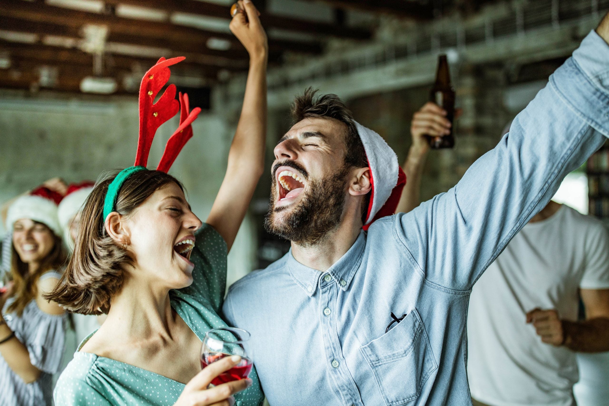 Happy couple having fun while singing on Christmas party.