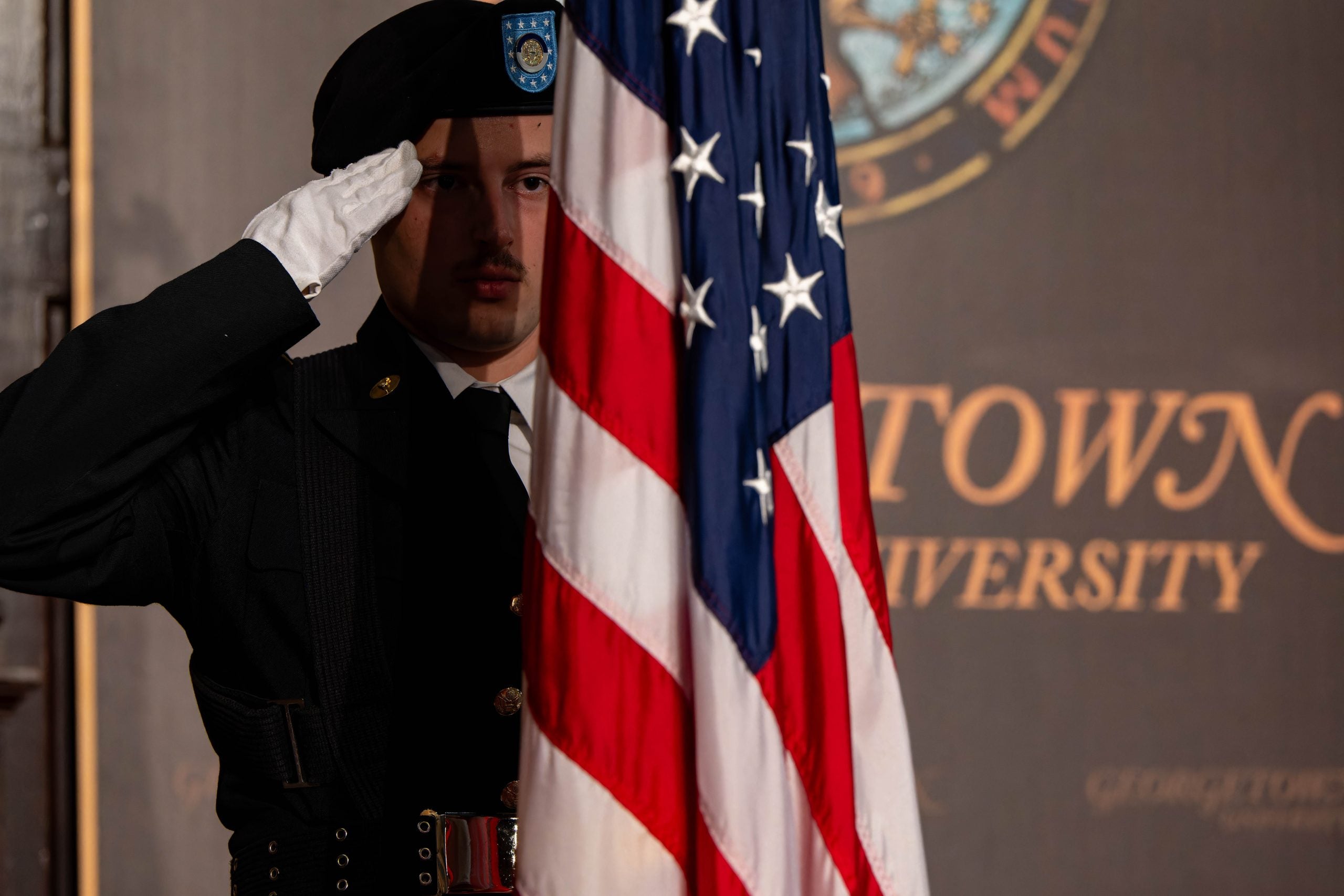 ROTC cadet saluting the American flag in Gaston Hall