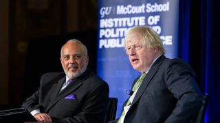 Two men sit on a stage at Georgetown.