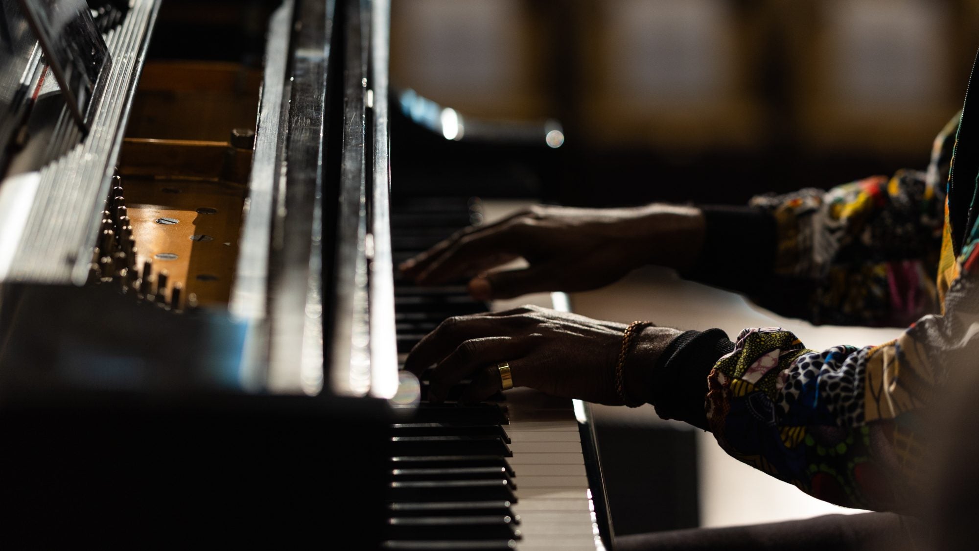 Hands of a Black man playing a piano