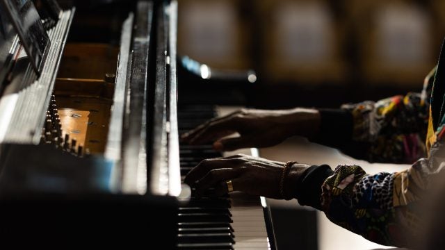 Hands of a Black man playing a piano