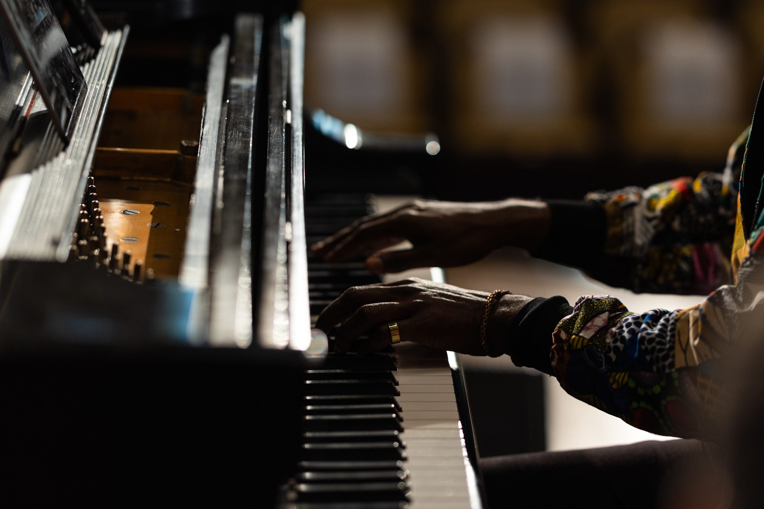 Hands of a Black man playing a piano