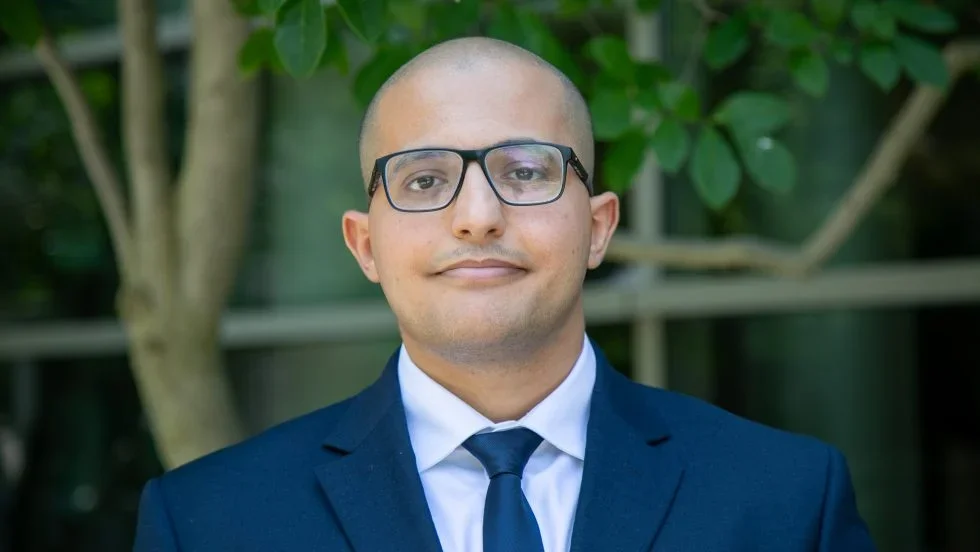 A headshot of a man wearing a suit and tie.