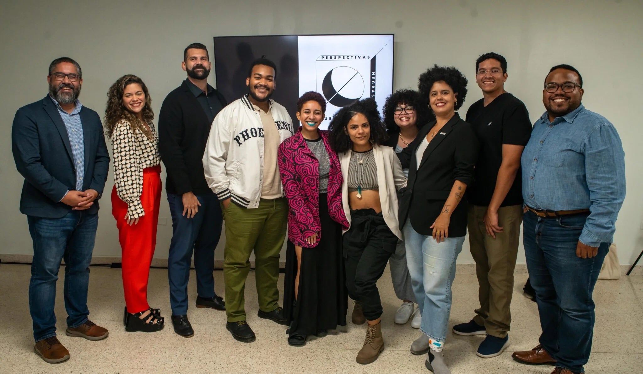 Ten people gathering in a room facing the camera.