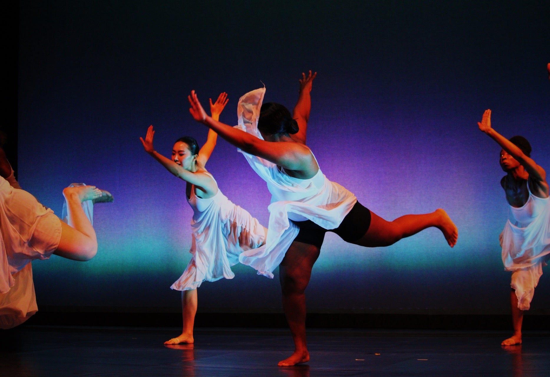 Young women performing on stage while wearing dancing apparel.