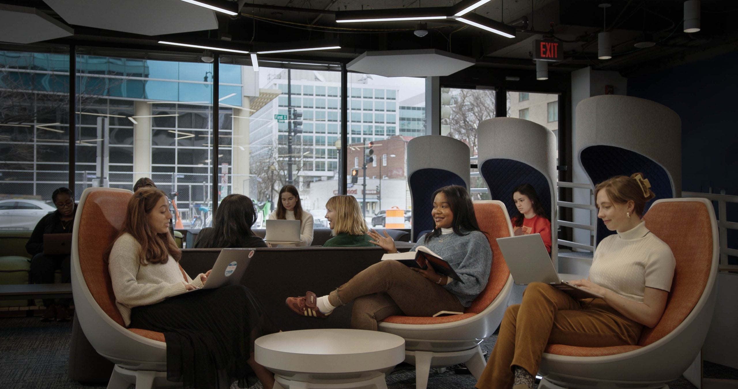 Students sitting and studying in study pods in an indoor space