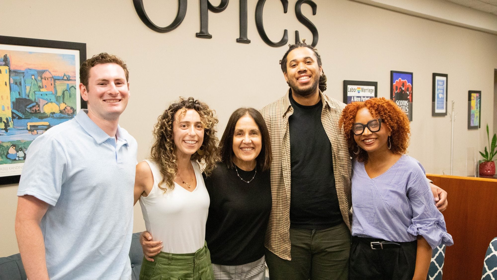 A group of students pose with a career counselor in an career services office.