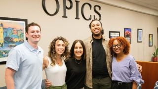 A group of students pose with a career counselor in an career services office.