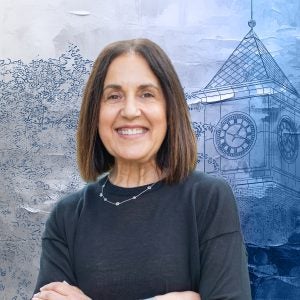 A woman with brown hair in a black shirt smiles in front of a textured, graphic drawing of a clocktower.