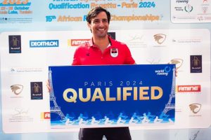 André Matias holding a blue sign that says "QUALIFIED."