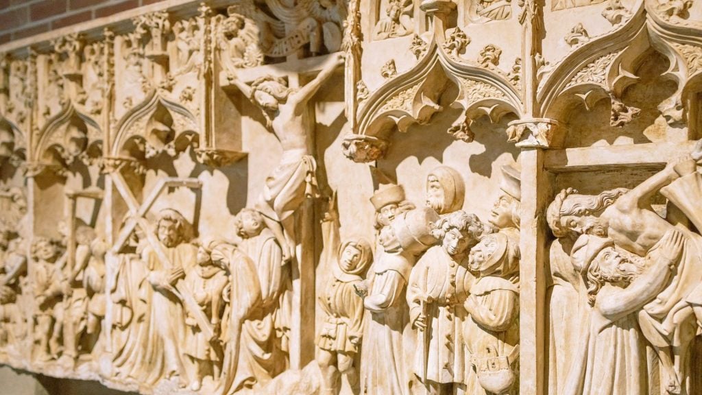 Jesus on the cross and scenes from the Passion carved into limestone at the Isabella Stewart Gardner Museum.