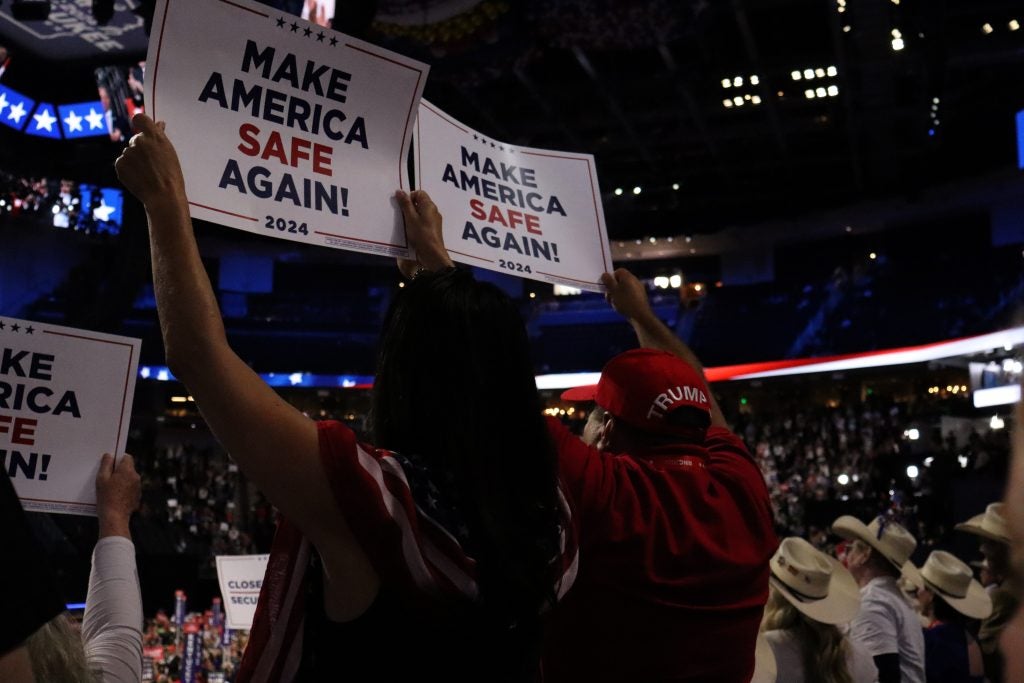 Two people holding up signs for Trump