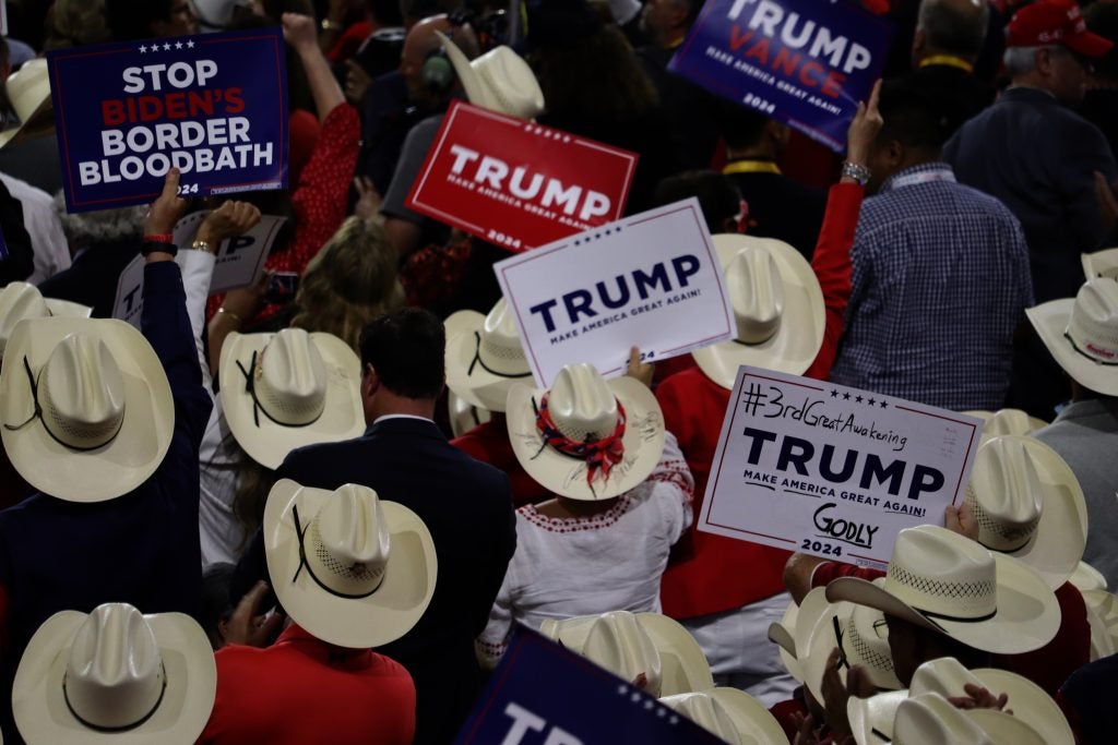 People in cowboy hats holding up Trump signs