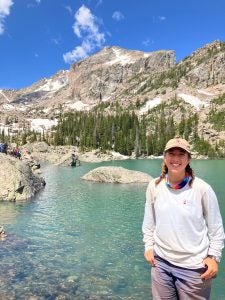 Jessie Traxler in the Rocky Mountains standing by a blue lake