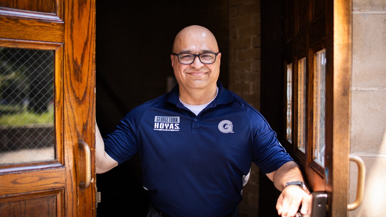 Haroot in a Georgetown polo standing in a doorway