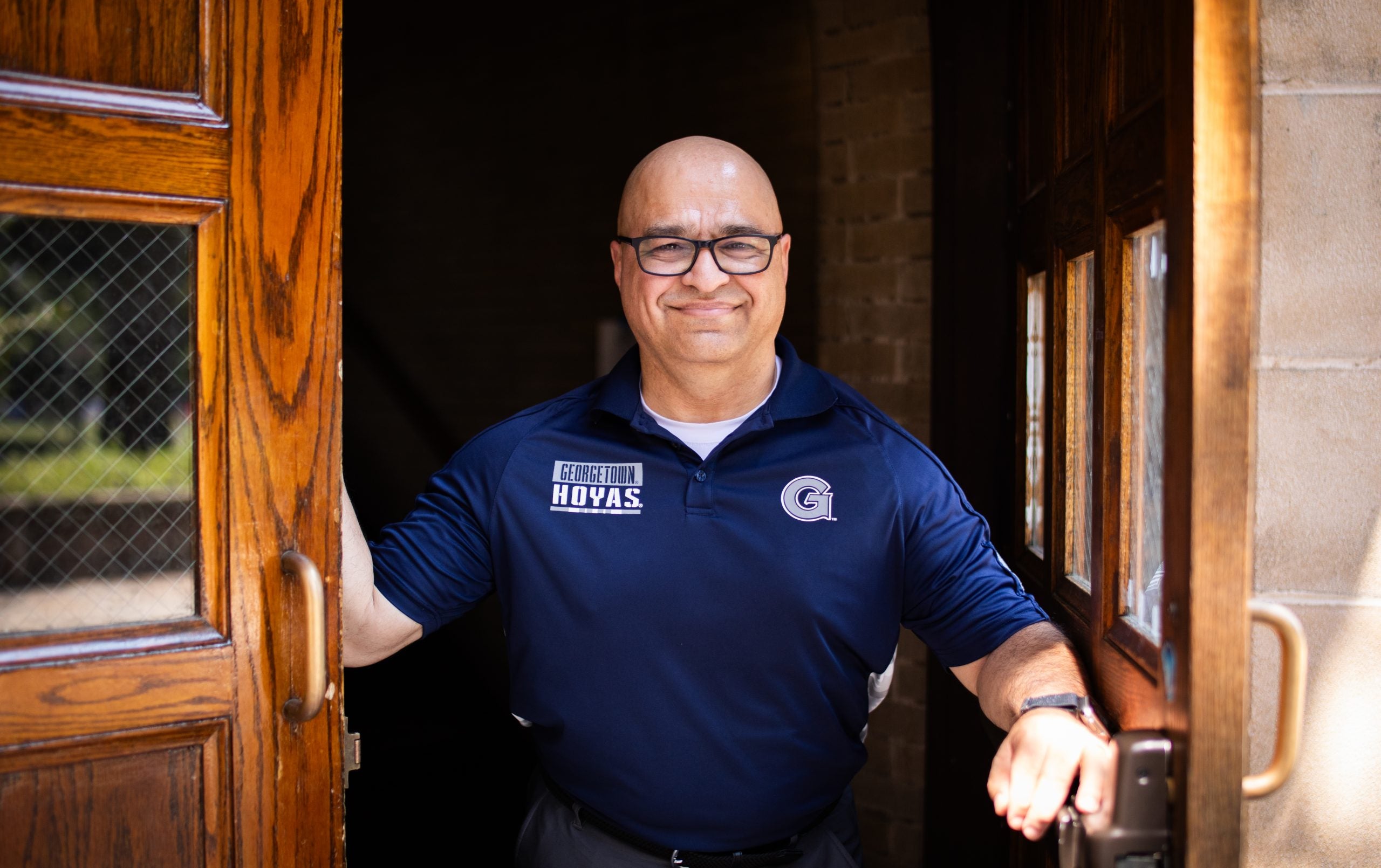 Haroot in a Georgetown polo standing in a doorway