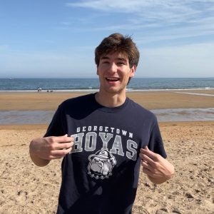 Alex shows off his Georgetown shirt on a sunny day at the beach