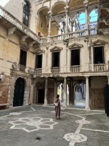 A student looks up at old building in Venice, Italy.