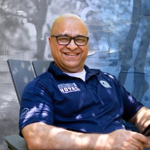 Stylized portrait of Haroot in a Georgetown shirt sitting in a chair