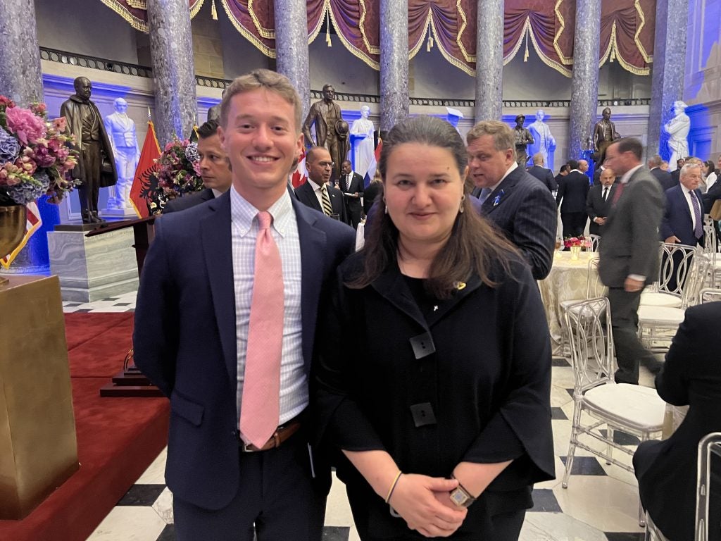 Hughes in a suit and tie standing next to the Ukrainian ambassador to the US at an official function