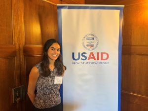 Ranee standing next to a USAID banner