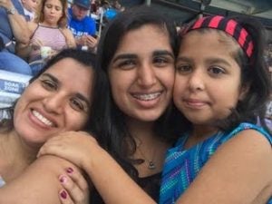 Three women smile and pose for a picture.