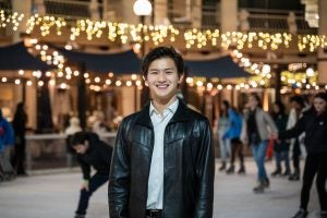 Bennie on an ice rink at night with sparkling lights in the background