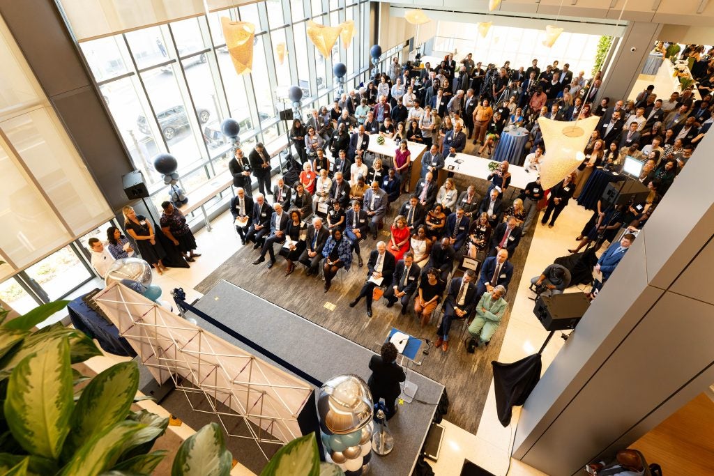 Overhead view of the atrium space filled with people in 125 E as Maria Cancian speaks