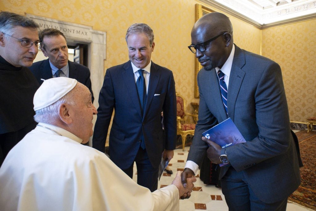 Deus Bazira greets Pope Francis at the Vatican.