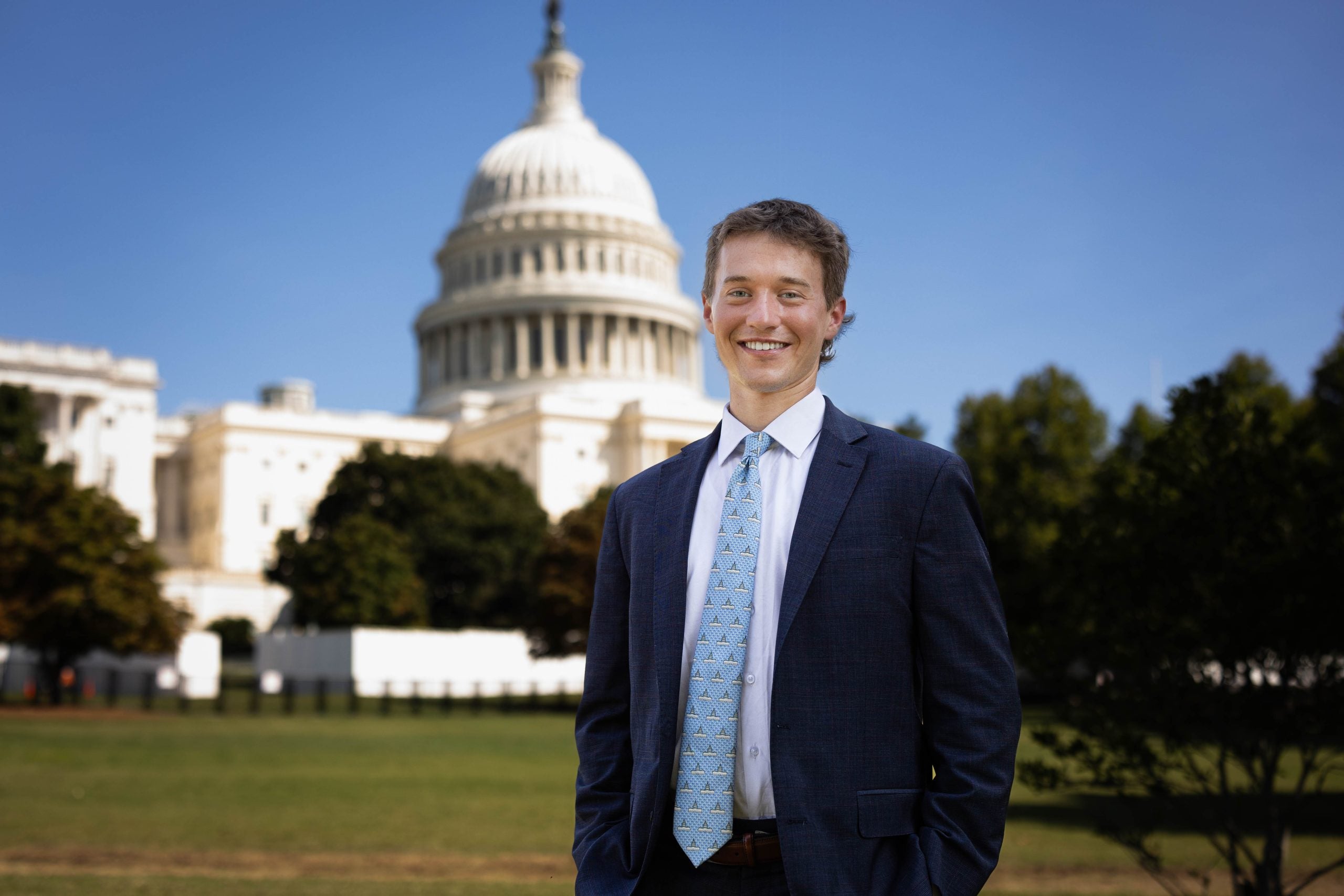 Luke Hughes in a suit and tie by the US Capitol on a clear day