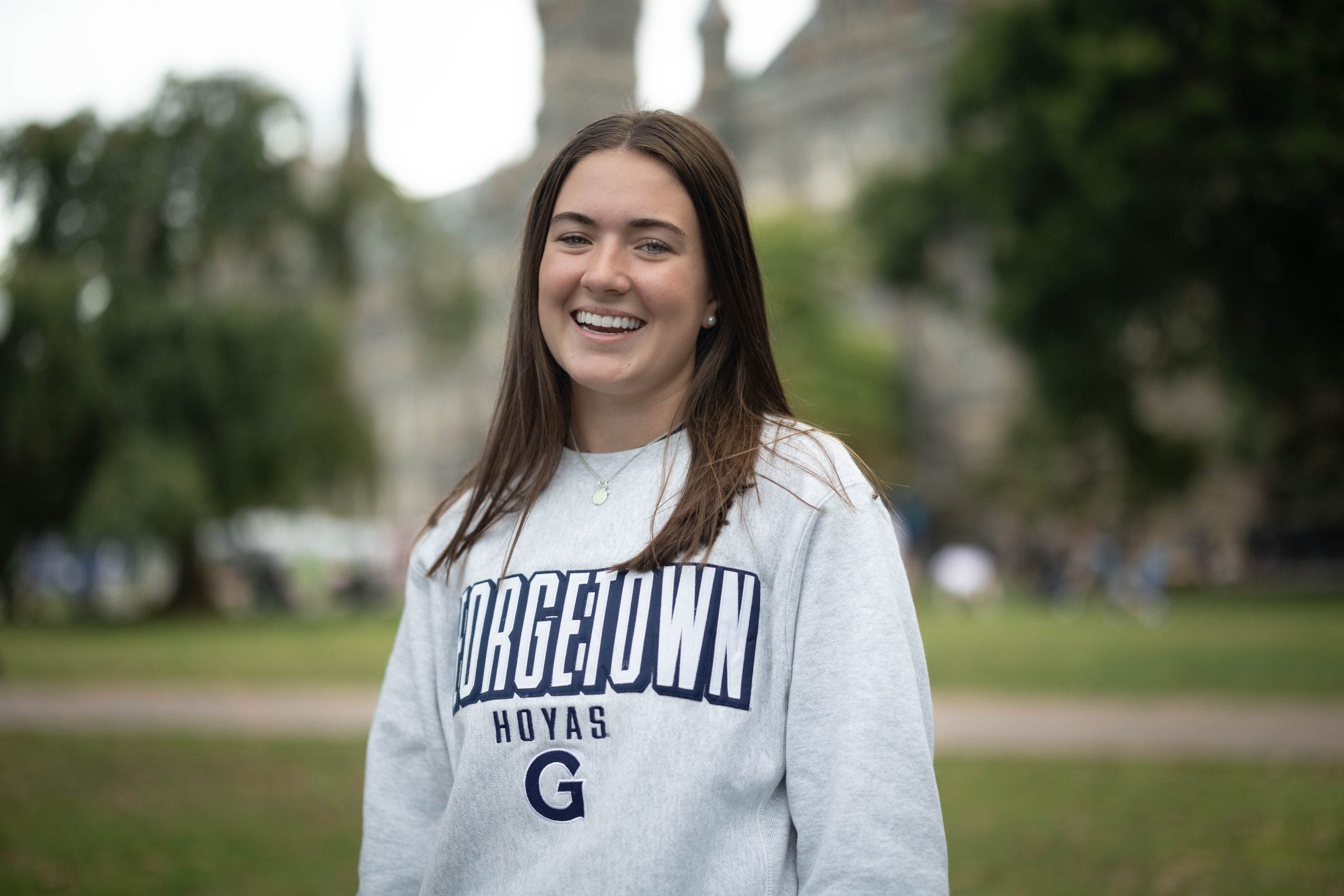 Sarah Brannigan wearing a light grey GU sweatshirt on Healy Lawn