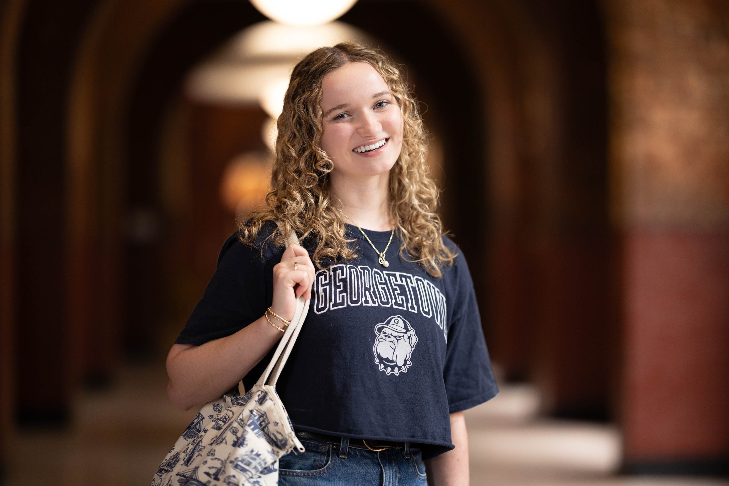 Grace Hardymon in a dark blue GU shirt in the halls of Healy Hall