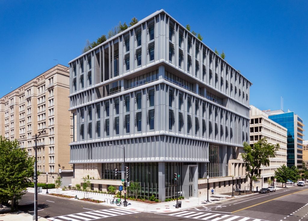 A sleek, gray building on the corner of a street in downtown Washington, DC.