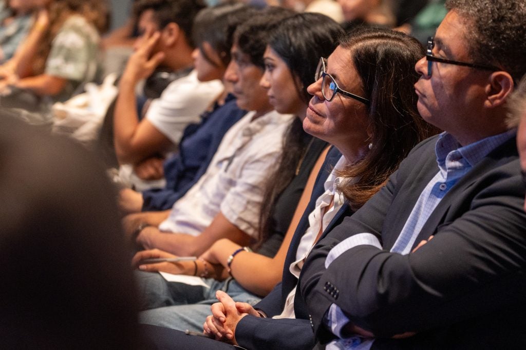 A close-up of audience members listen to panelists.