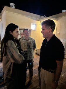 Gillen speaking to a young woman at night with a FBI agent in the background